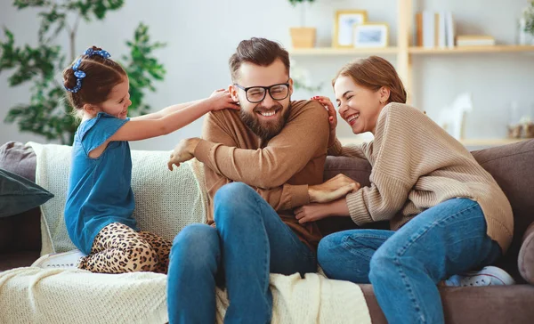 Mutlu aile anne baba ve çocuk kız evde gülüyor — Stok fotoğraf