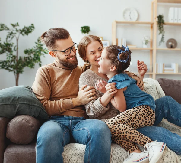 Mutlu aile anne baba ve çocuk kız evde gülüyor — Stok fotoğraf