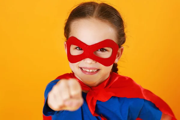 Pojęcie dziecka kostium superbohatera na żółtym tle — Zdjęcie stockowe