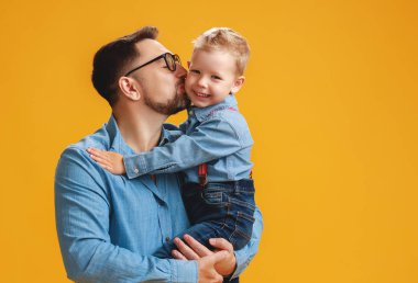 Babalar günün kutlu olsun! sevimli baba ve oğlu sarı backgroun sarılma