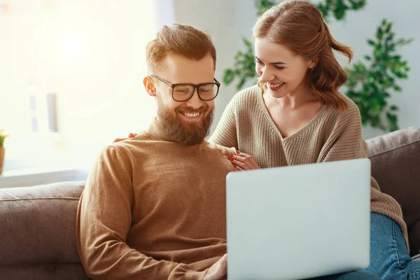 Feliz pareja con ordenador portátil en casa —  Fotos de Stock