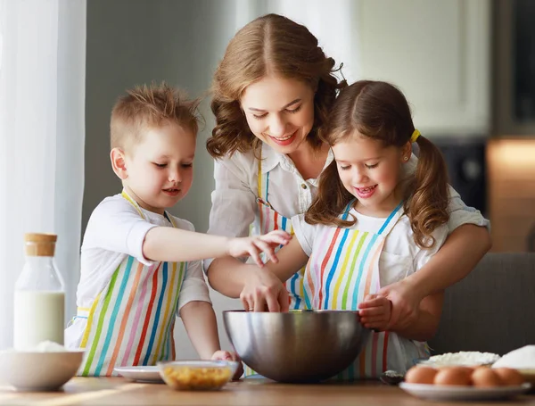 Familia feliz en la cocina. madre e hijos preparando la masa, ba — Foto de Stock