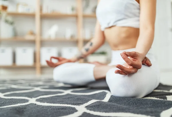 Mulher fazendo ioga, meditando na posição de lótus em casa — Fotografia de Stock