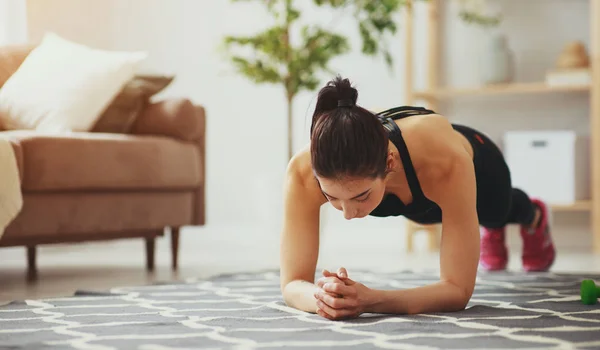 Mujer joven haciendo ejercicio y deportes en casa — Foto de Stock