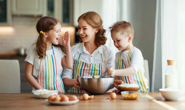 Glückliche Familie in der Küche. Mutter und Kinder bereiten Teig zu, — Stockfoto