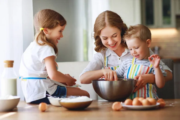 Família feliz na cozinha. mãe e filhos preparando massa, ba — Fotografia de Stock