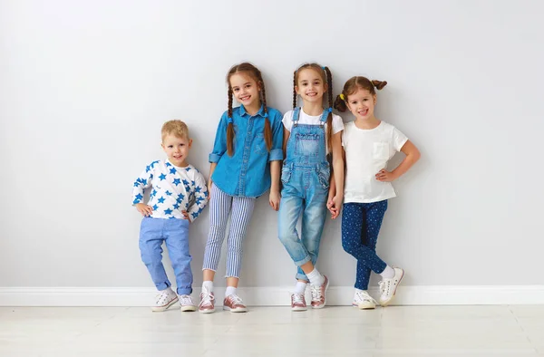 Happy kids friends around empty wall — Stock Photo, Image