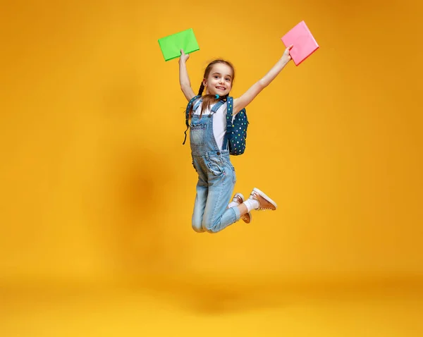 Criança engraçada menina da escola no fundo amarelo — Fotografia de Stock