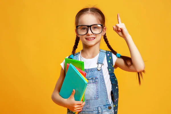 Niña divertida niña de la escuela sobre fondo amarillo —  Fotos de Stock