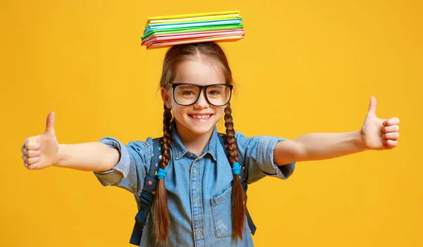 Смішна дівчинка в школі на жовтому фоні — стокове фото