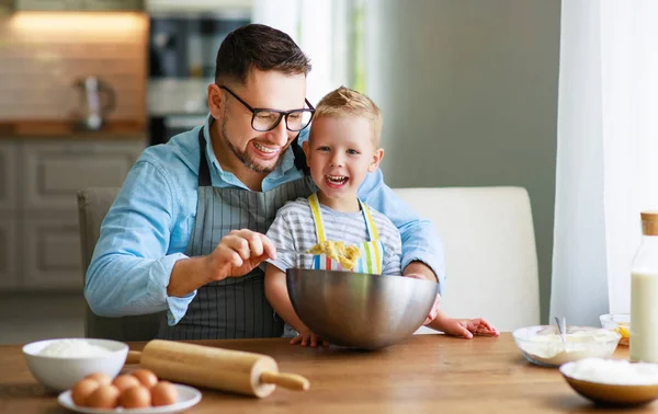 Счастливая семья на кухне. отец и ребенок пекут печенье — стоковое фото