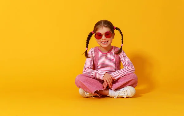 Lustige lustige Kindermädchen in rosa Kleidern auf gelbem Hintergrund — Stockfoto