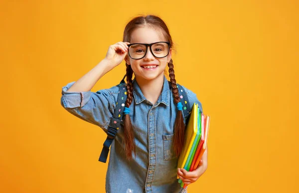 黄色の背景に面白い児童学校の女の子 — ストック写真