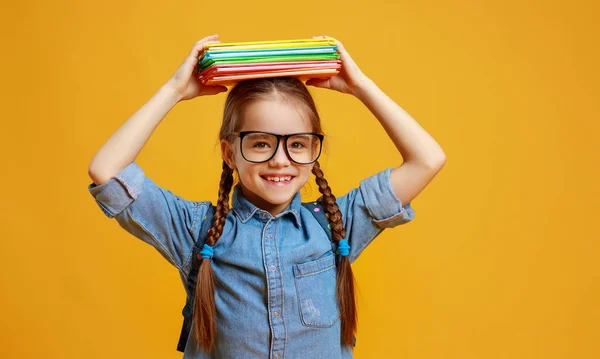 Lustige Kind Schulmädchen auf gelbem Hintergrund — Stockfoto