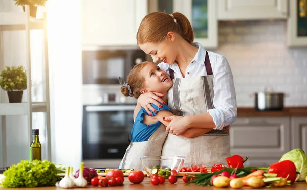 Glückliche Familienmutter mit Kind bereitet Gemüsesalat zu — Stockfoto