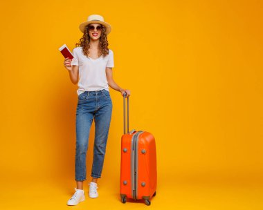 Seyahat konsepti. Bavulu ve pasaportu olan mutlu bir kadın. 