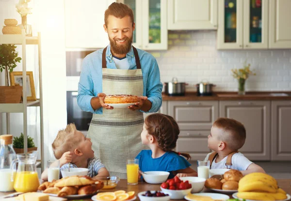 Счастливый отец семьи с детьми кормит своих сыновей и дочь в — стоковое фото