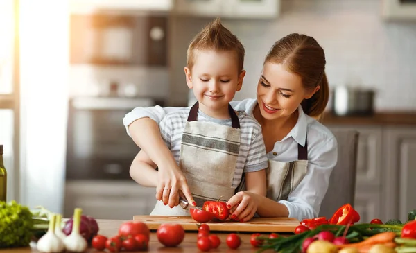 Glückliche Familienmutter mit Sohn bereitet Gemüsesalat zu — Stockfoto