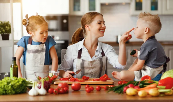 Mutter mit Kindern bereitet Gemüsesalat zu — Stockfoto