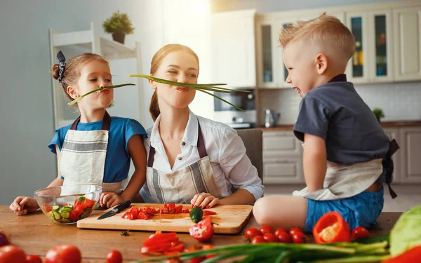 Мать с детьми готовит овощной салат — стоковое фото