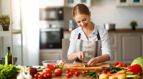 Lycklig kvinna förbereder grönsakssallad i omgivni — Stockfoto