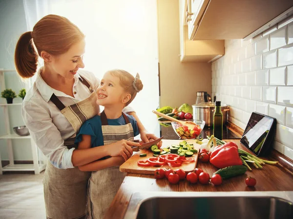 Glückliche Familienmutter mit Kind bereitet Gemüsesalat zu — Stockfoto