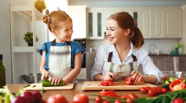 Glückliche Familienmutter mit Kind bereitet Gemüsesalat zu — Stockfoto