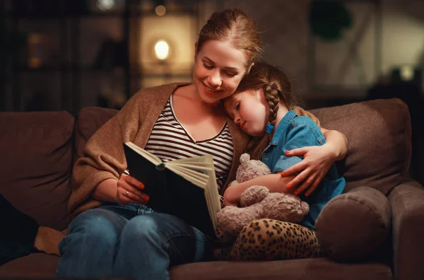 Family before going to bed mother reads to her child daughter bo — Stock Photo, Image