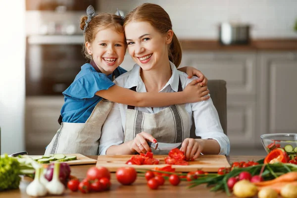 Glückliche Familienmutter mit Kind bereitet Gemüsesalat zu — Stockfoto