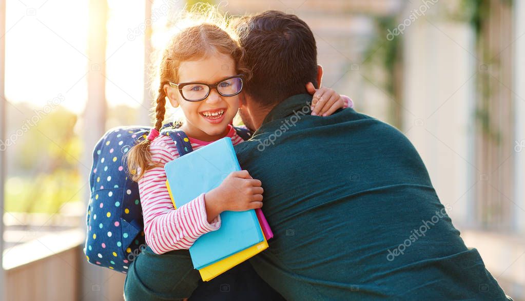 first day at school. father leads  little child school girl in f