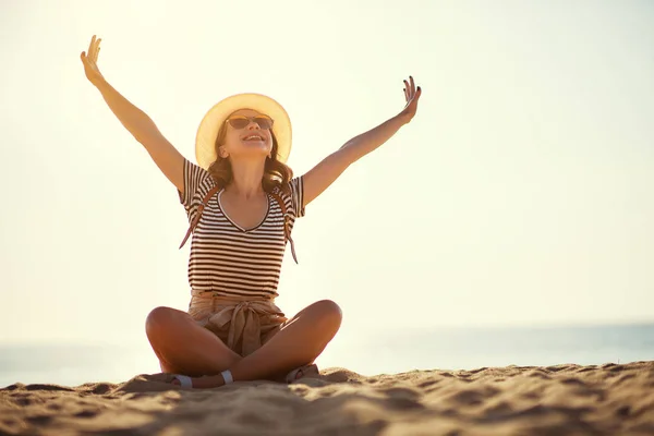 Happy tourist girl with backpack and hat on sea — Stock Photo, Image