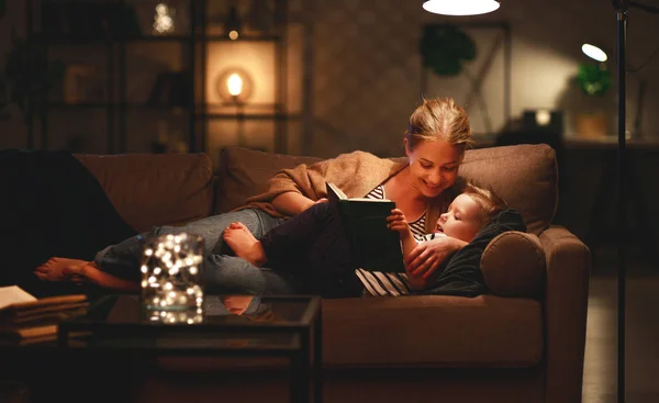 Familie voor het gaan naar bed moeder leest aan haar kind zoon boek ne — Stockfoto