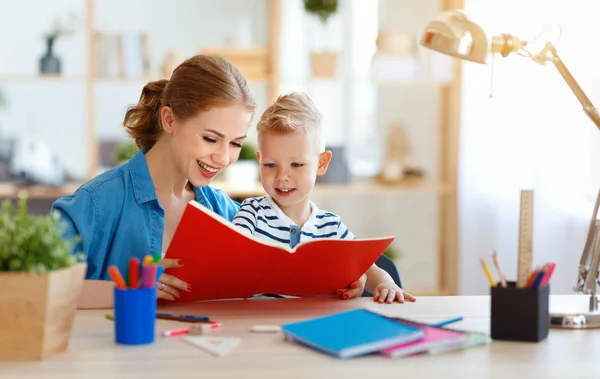 Mother and child son doing homework writing and reading at hom — Stock Photo, Image