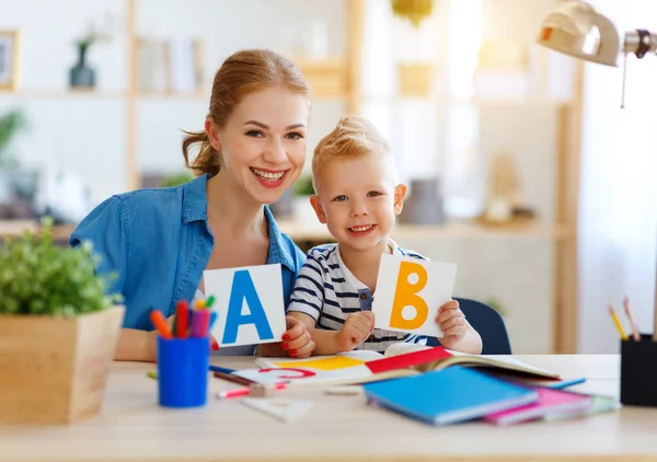 Madre e figlio figlio a fare i compiti di scrittura e lettura a hom — Foto Stock