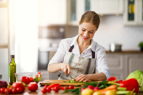 Mulher feliz preparando salada de legumes na cozinha — Fotografia de Stock