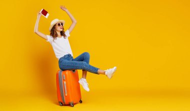 Seyahat konsepti. Bavulu ve pasaportu olan mutlu bir kadın. 