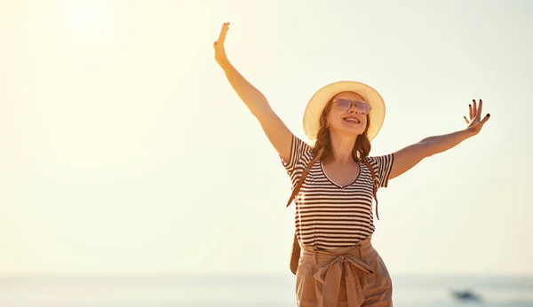 Chica turística feliz con mochila y sombrero en el mar —  Fotos de Stock