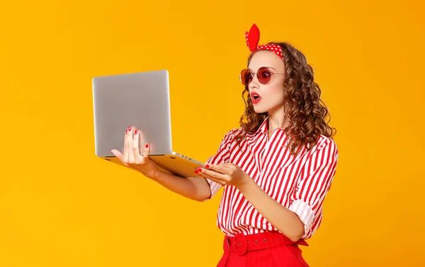 Mulher alegre engraçado com laptop no fundo amarelo — Fotografia de Stock