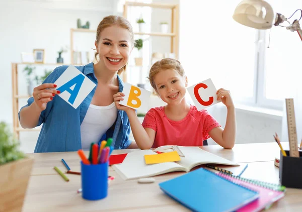 Mor och barn dotter gör läxor skriva och läsa på — Stockfoto