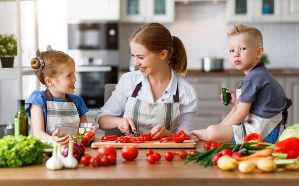 Mutter mit Kindern bereitet Gemüsesalat zu — Stockfoto