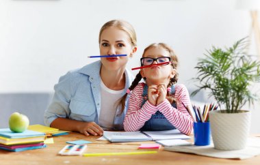 komik anne ve çocuk kızı ödev yazma ve hazır yapıyor