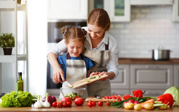 Счастливая мать семьи с ребенком девочка готовит овощной салат — стоковое фото