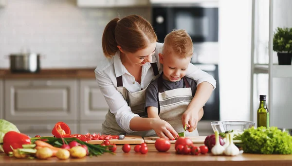 Glückliche Familienmutter mit Sohn bereitet Gemüsesalat zu — Stockfoto