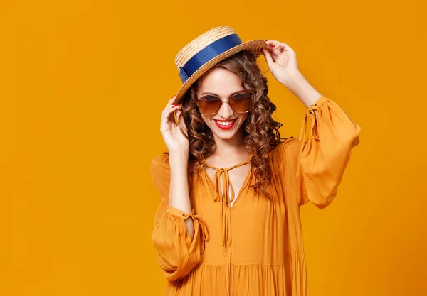 Mooie jonge krullend vrouw in zomer hoed en zonnebril op gij — Stockfoto