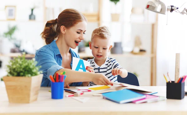 Madre e figlio figlio a fare i compiti di scrittura e lettura a casa — Foto Stock