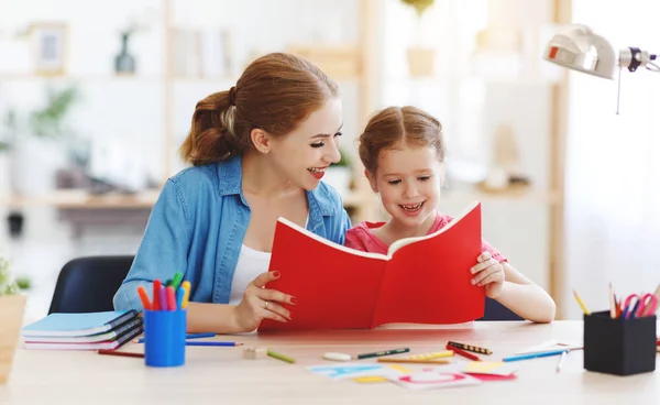 Mutter und Kind beim Hausaufgabenschreiben und Lesen — Stockfoto