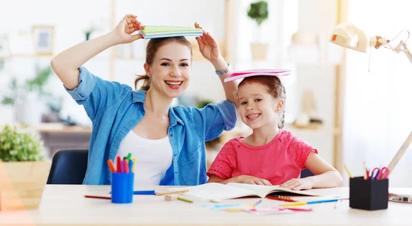 Lustige Mutter-Kind-Tochter beim Hausaufgabenschreiben und Lesen — Stockfoto