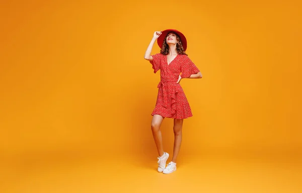 Concepto feliz mujer joven emocional en vestido de verano rojo y sombrero — Foto de Stock