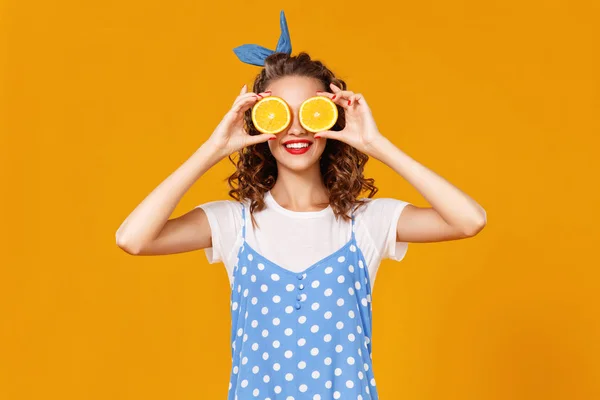 黄色のバクにオレンジを持つ陽気な若いカーリー女性の女の子 — ストック写真