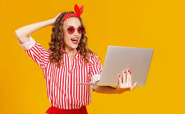 Divertente donna allegra con computer portatile su sfondo giallo — Foto Stock